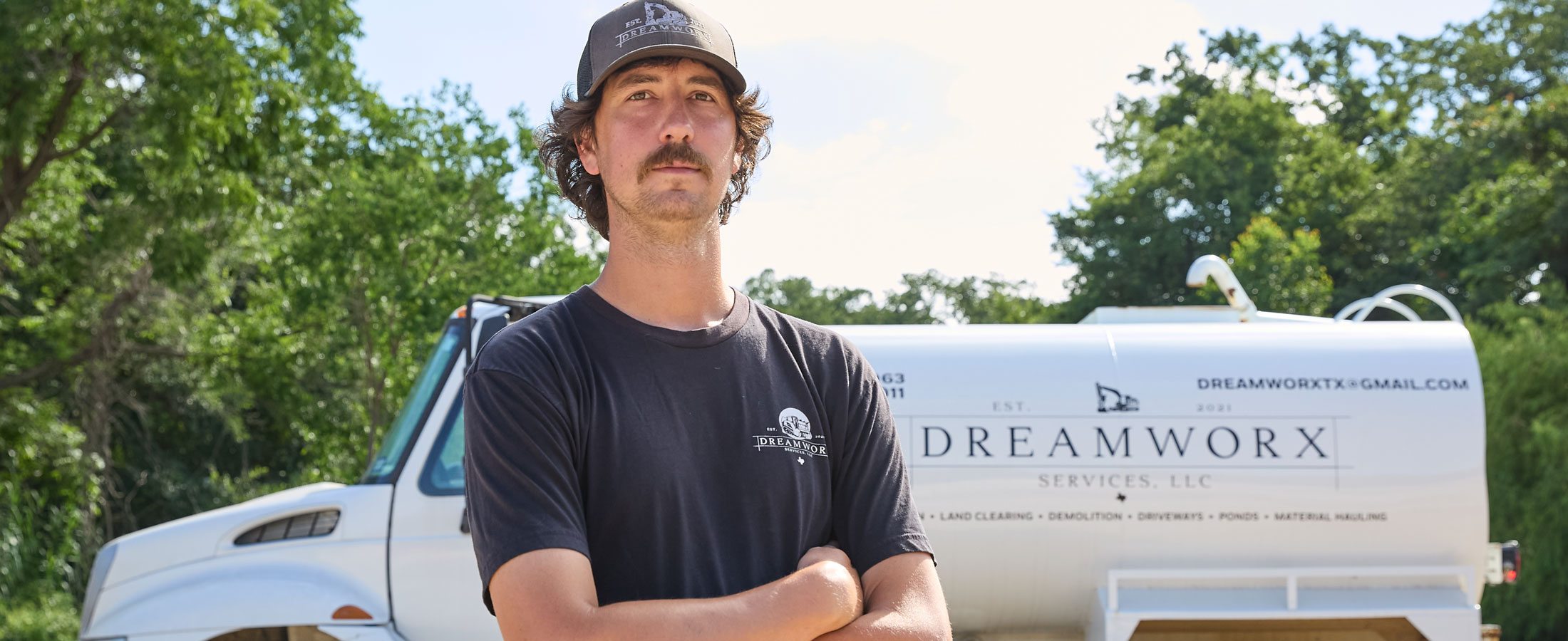 A man, Nick Castillion standing in front of a truck.